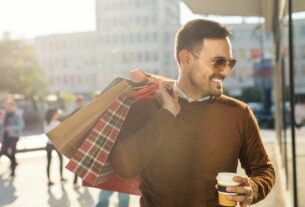 Homem carregando sacolas de compras em área urbana, representando opções variadas de compras em Santa Catarina em diferentes cidades e centros comerciais.